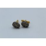A pair of gilt silver skull cufflinks set with an estimated 1.80 carats of rose cut diamonds.