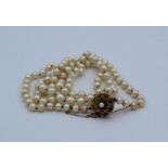 A cultured pearl single strand necklace with 9 carat gold flower form box clamp
