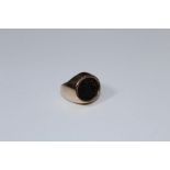 An unmarked 9ct gold signet ring, set with bloodstone shield crest intaglio, to a plain shank,