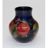 A 1930's William Moorcroft Pomegranate pattern vase of baluster form, decorated with red fruits on a