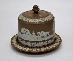 An early 20th century brown dip cheesedish and cover, decorated in shallow relief with hunting scene
