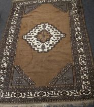 A Persian Nomadic style hand knotted carpet having a brown ground with ivory medallion, 330 x 219cm