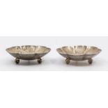 A pair of 20th Century possibly American silver flower shaped pin dishes, on three circular feet,