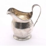 A George III silver helmet shaped milk/cream jug with bright cut engraved decoration to body,