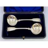 A pair of Victorian fiddle, thread and shell pattern silver sauce ladles, hallmarked by London,