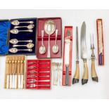 A collection of plated flatware in boxes and cases in a carving set