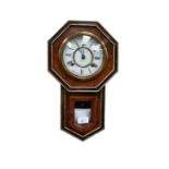 A Seiko of Tokyo wall clock in wooden casing with pendulum and key within casing.