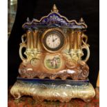 A large Edwardian ceramic mantel clock on a stand.