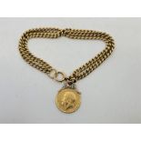 An 18ct. gold double curb link bracelet, each linked stamped "18", suspending George V sovereign (