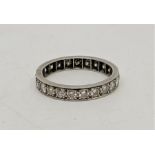 A precious white metal diamond eternity ring, set twenty-three round brilliant cut diamonds, (ETDW