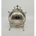 A silver plated biscuit warmer, engraved foliate wreaths to circular hinged warmer, opening to