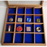 Eight various Art Deco compacts, displayed in a sixteen division glazed table top blue baize lined