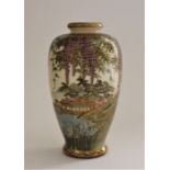 A Japanese Meiji period Satsuma baluster vase painted with wisteria blossom a building and