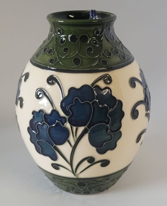 A boxed Moorcroft vase, decorated in the Golden Age pattern  , decorated with  b;lue flowers on a