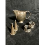 A pair of Art Deco style candle snuffers, Stylish Jug and two napkin rings.  Hallmarked Silver