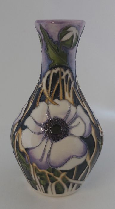 A Boxed Moorcroft vase titled  " Peace Anemone " it is decorated in shades of lilacs with large