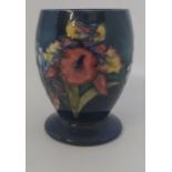 A Boxed Moorcroft vase, titled  " Orchid Blue "  it is decorated with colourful orchids in reds