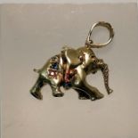 A 9ct gold articulated Elephant pendant, set with rubies and blue and white stones. Gross weight