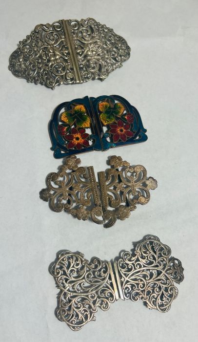 A collection of four nurses belt buckles. Featuring a sterling silver scroll work buckle, marked for