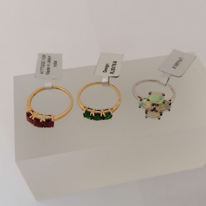 Three 9ct gold gem set rings by Gemporia. The first set with three oval cut rubies (lead glass