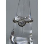 A Bucherer Diamond ring. A white metal and diamond cluster ring, featuring a central diamond of an