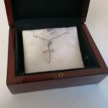 A 750 stamped white metal cross, set with round cut diamonds on a beaded chain. Gross weight