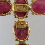 A cabochon ruby set cross, signed Paola B. Featuring six cabochons of ruby set in yellow metal