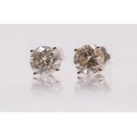 A pair of diamond solitaire white gold earrings, comprising a claw set round brilliant cut
