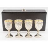 A set of 4 white base metal small goblets in a fitted case.