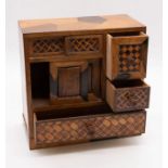A Japanese Kodansu wooden cabinet, used for incense, with parquetry inlay and drawers opening