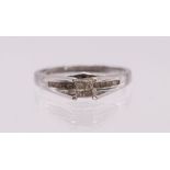 A diamond and 14ct white gold ring, comprising four princess cut diamonds set to tension/ claw