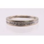 A diamond and 14ct white gold half eternity ring, comprising a row of nine channel set round