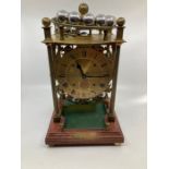A Harding and Bazerley Spherical wheel clock, Brass posted movement raised on a mahogany style