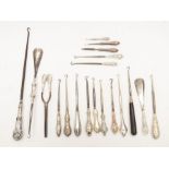A collection of silver handled button hooks, shoe horns and other items, featuring a variety of