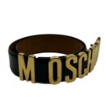 A Moschino black glace leather belt with gold tone metal lettering, fastens 89cm long fastens to a