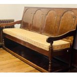 A George III oak settle with later elements, four arch moulded panels back rests, scrolling arms,