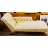 A 20th Century upholstered chaise lounge, scrolling button back rest, raised on regency sabre