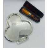 An Edward VII club shaped card tray and a white metal collared amber cheroot holder in case. Card