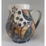 A boxed Bramble Jug made by Moorcroft. Decorated with blackberries and autumn leaves in shades of