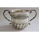 A Queen Anne style silver loving cup with partial wrythen moulding, twin foliate scrolling handles