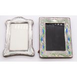 A pair of Arts & Crafts style photograph frames in silver. The first, stamped "STERLING", features