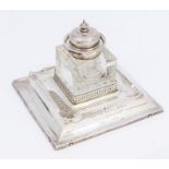 A George V silver ink stand with detachable glass ink bottle with silver collar and hinged domed