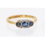 A diamond and sapphire 18ct gold three stone ring, comprising three graduated mixed cut sapphires,