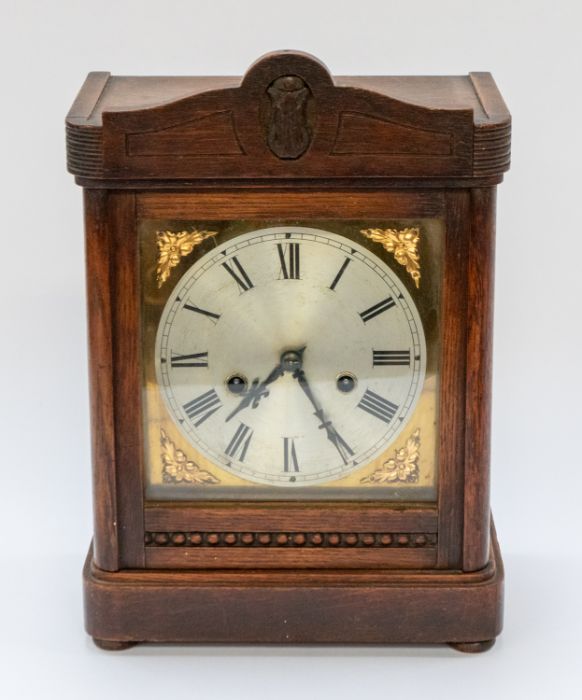 A wooden mantle clock, with brass details