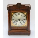 A wooden mantle clock, with brass details