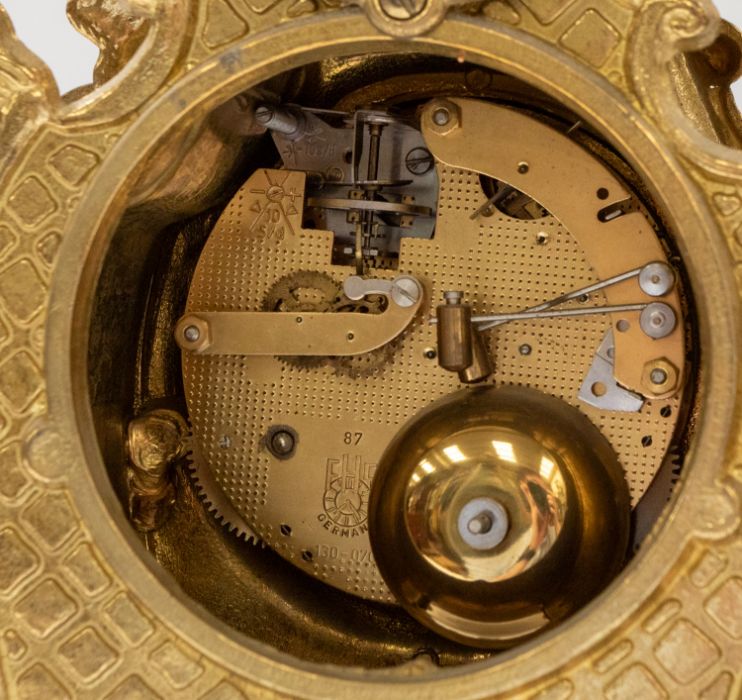 A brass mantle clock along with matching pair of candelabra, all decorative with cherub and gilt - Image 3 of 3