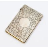 An Edwardian silver card case, profuse scrolling stylised fern leaf decoration with central vacant