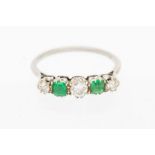 An emerald and diamond unmarked white metal five stone ring, comprising three brilliant cut