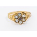 A Victorian pearl and garnet set gold ring, comprising a flower cluster set to the centre with a