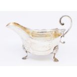 A George V silver sauce boat, C scroll handle on three shell and hoof feet, hallmarked by Manoah